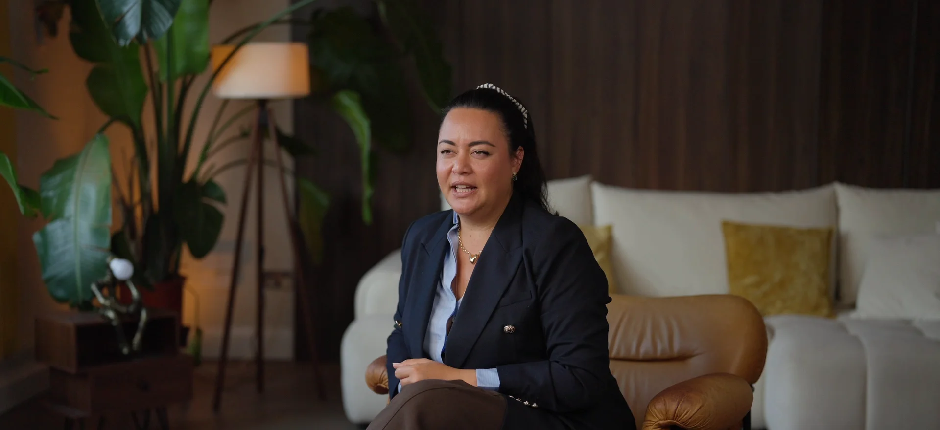 Victoria Bhouddhavongs, founder of The Property Story, in a navy blazer during her filmed interview in a living-room studio set in London