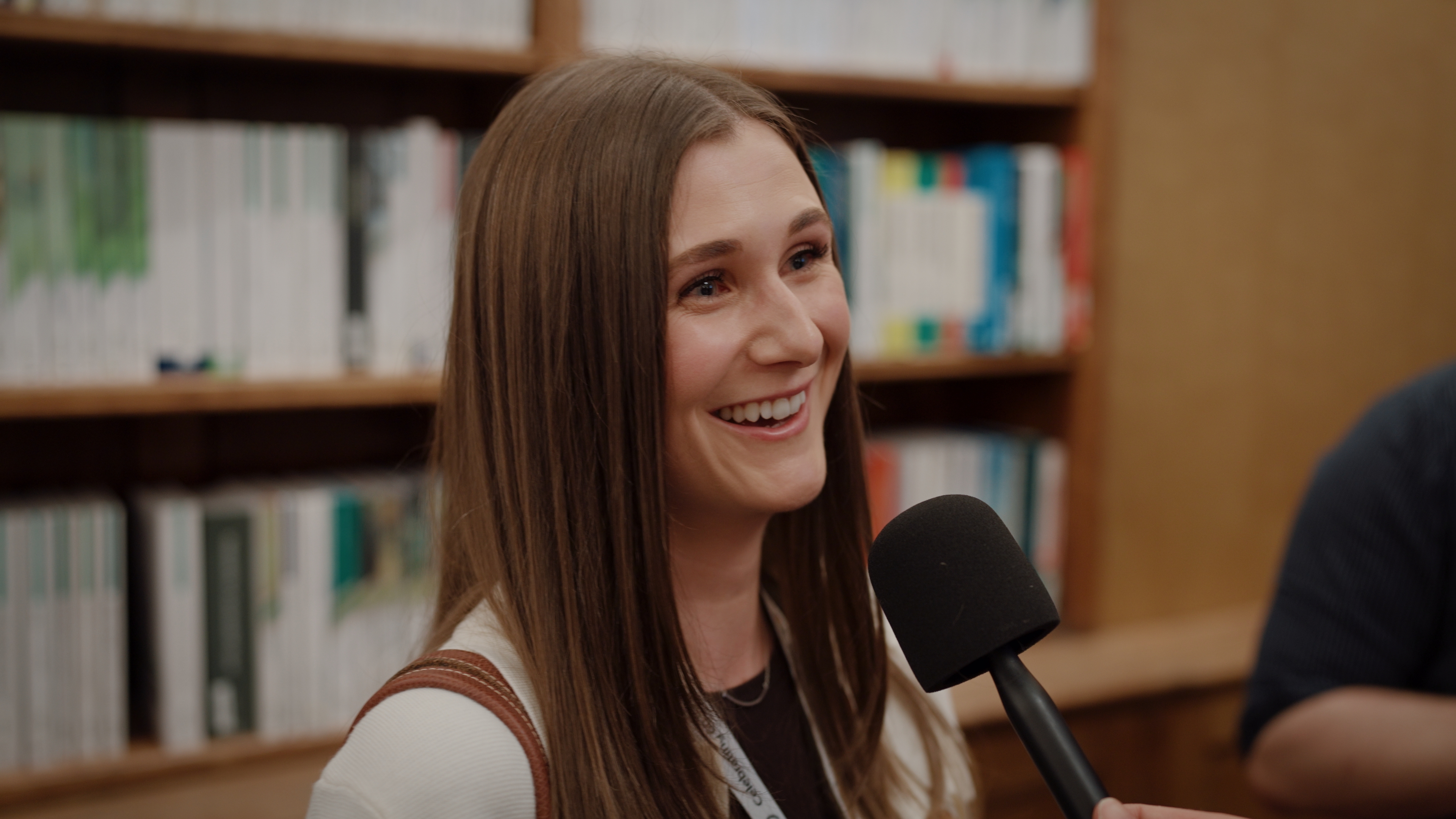 A perfumer speaking on camera during a filmed interview at a British Society of Perfumers event in London.